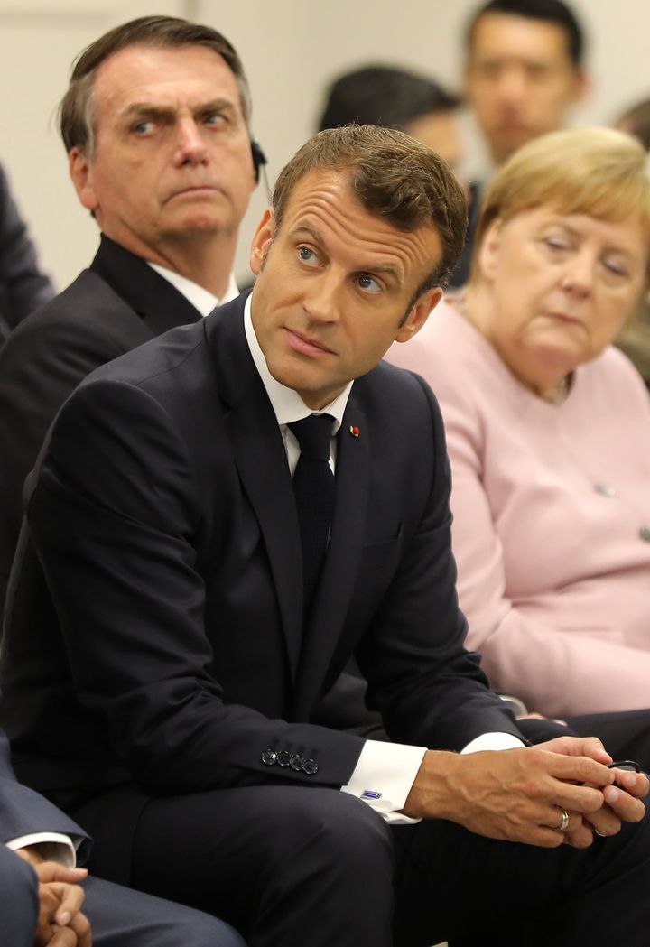 France's President Emmanuel Macron sits with Brazil's President Jair Bolsonaro (back L) and Germany's Chancellor Angela Merkel at an event on the theme "Promoting the place of women at work" on the sidelines of the G20 Summit in Osaka on June 29, 2019. (Photo by Dominique JACOVIDES / POOL / AFP) (Photo credit should read DOMINIQUE JACOVIDES/AFP/Getty Images)