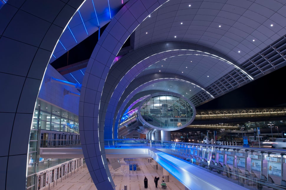 Dubai, UAE - November 18, 2011: People moving around the futuristic looking Dubai Airport, home to the award winning Emirates Airline.