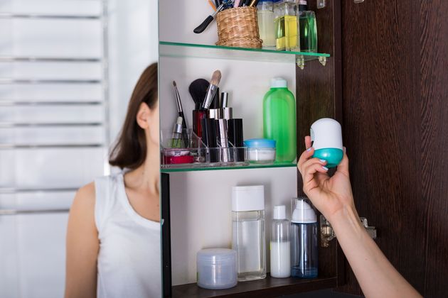 Morning routine. Young woman using cosmetics at her