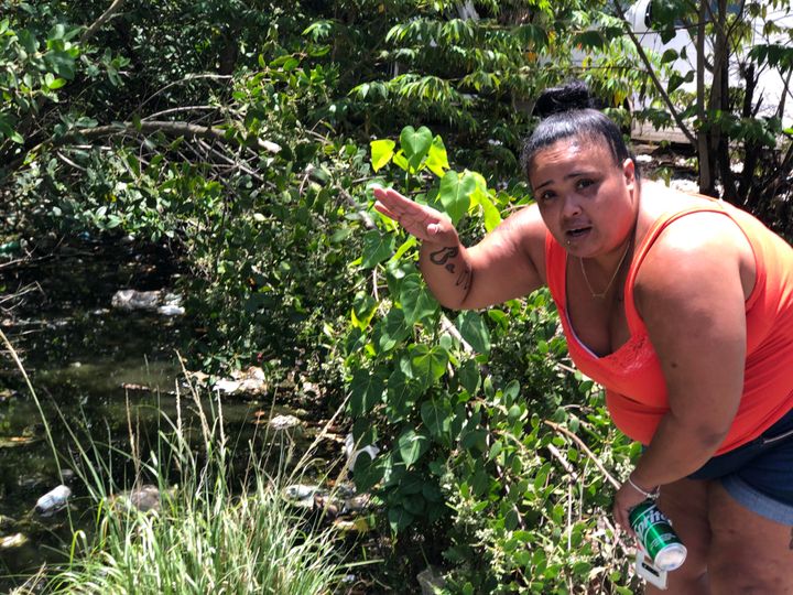 Milagros Figueroa gestures next to the Caño Martín Peña, a nearly four-mile polluted canal that she said floods during heavy rainfall.