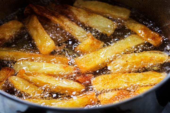 French fries fry in hot bubbling oil in a frying pan