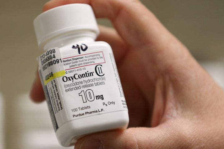 In this file photo, a pharmacist holds a bottle OxyContin made by Purdue Pharma.