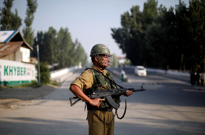 A security personnel stands guard on a deserted road during restrictions in Srinagar, August 23, 2019. 