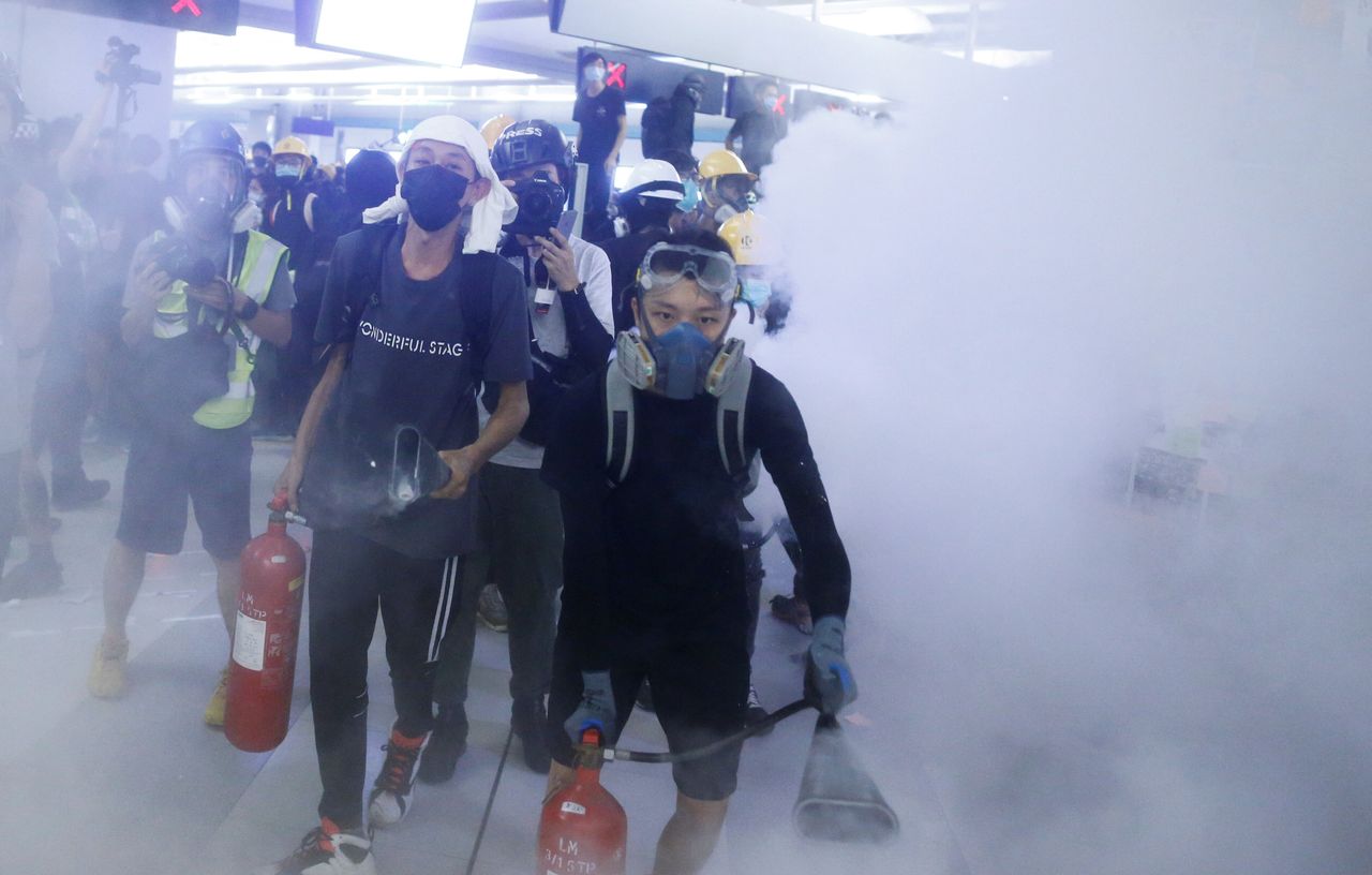 Protesters fire nitrogen extinguishers during a stand off at Yuen Long MTR station, the scene of an attack by suspected triad gang members a month ago, in Yuen Long, New Territories, Hong Kong August 21, 2019. 