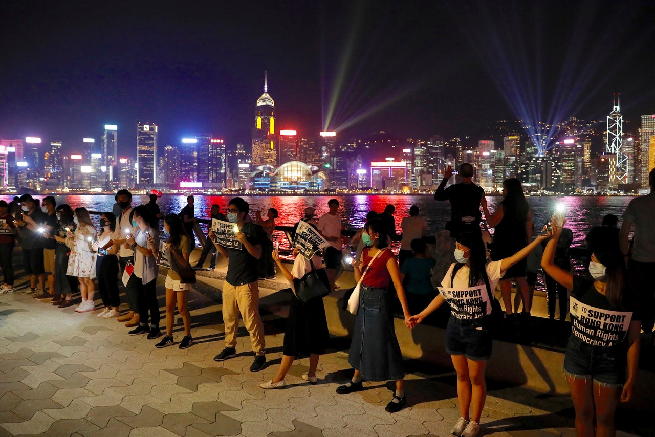 Demonstrators link hands as they gather at the Tsim Sha Tsui waterfront in Hong Kong, Friday, Aug. 23, 2019. 