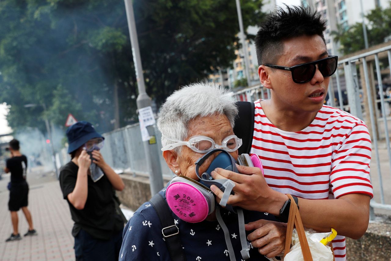 A woman is helped by a demonstrator after police fired tear gas during a demonstration in support of the city-wide strike and to call for democratic reforms at Tin Shui Wai in Hong Kong, August 5, 2019. 