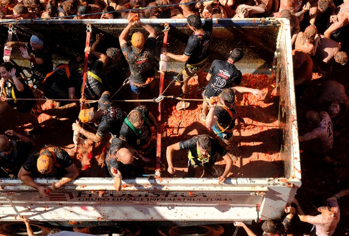 Revellers on a truck throw tomatoes into the crowd during the annual "La Tomatina" food fight festival in Bunol, near Valencia, Spain, August 28, 2019. REUTERS/Heino Kalis