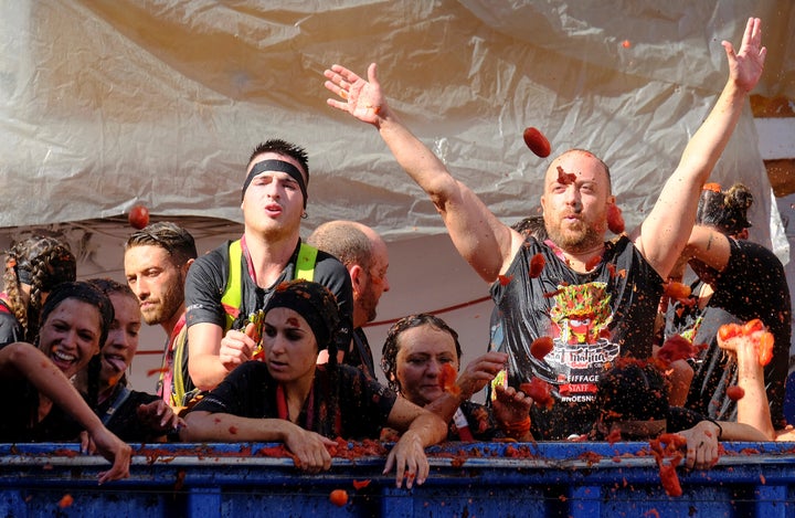 Revellers on a truck throw tomatoes into the crowd during the annual "La Tomatina" food fight festival in Bunol, near Valencia, Spain, August 28, 2019. REUTERS/Heino Kalis