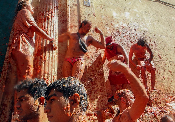 Participantes se arrojan tomates los unos a los otros en el evento anual Tomatina, una festiva batalla de tomates en el pueblo de Buñol, cerca de Valencia, España, el miércoles 28 de agosto de 2019. (AP Foto/Alberto Saiz)