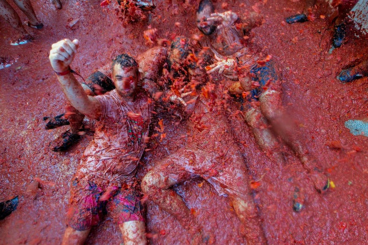 Revellers throw tomatoes at each other, during the annual "Tomatina" tomato fight fiesta, in the village of Bunol, near Valencia, Spain, Spain, Wednesday, Aug. 28, 2019. The party saw 145 tons of tomatoes offloaded from six trucks into crowds packing Bunol's streets for the midday hourlong battle Wednesday. (AP Photo/Alberto Saiz)