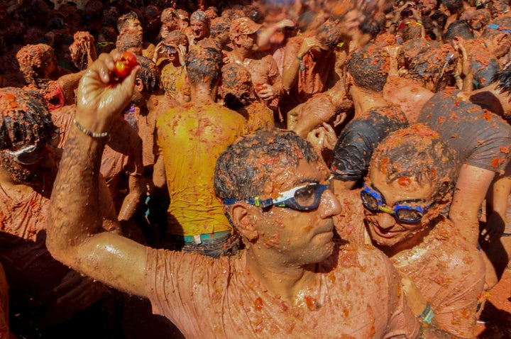 Participantes se arrojan tomates los unos a los otros en el evento anual Tomatina, una festiva batalla de tomates en el pueblo de Buñol, cerca de Valencia, España, el miércoles 28 de agosto de 2019. (AP Foto/Alberto Saiz)