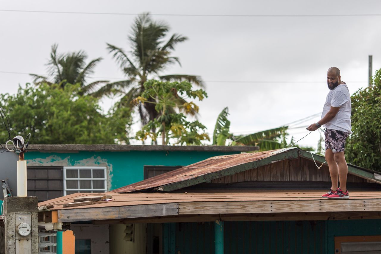 Lemuel Otero, 40, battening down the roof at his property in Maternillo, Fajardo, as Puerto Rico prepares to be hit by Tropical Storm Dorian on Wednesday, Aug. 28.