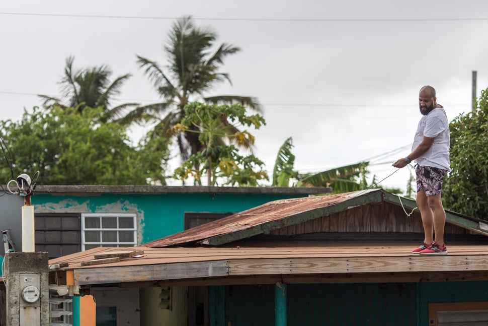 Lemuel Otero, 40, battening down the roof at his property in Maternillo, Fajardo, as Puerto Rico prepares to be hit by Tropic