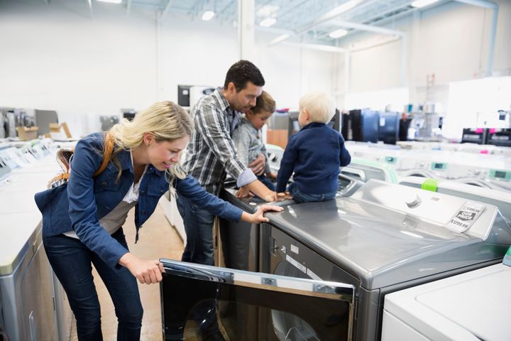 Young family shopping for clothes washer in appliance store