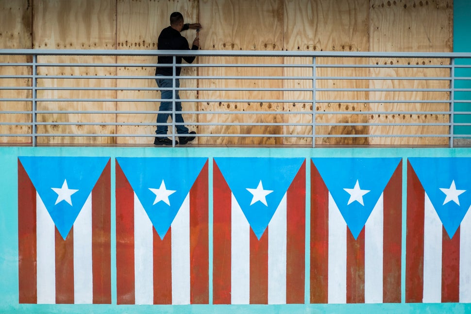 A man finishes boarding up a restaurant at the Naguabo Malecon in Naguabo, Puerto Rico, on Wednesday. 