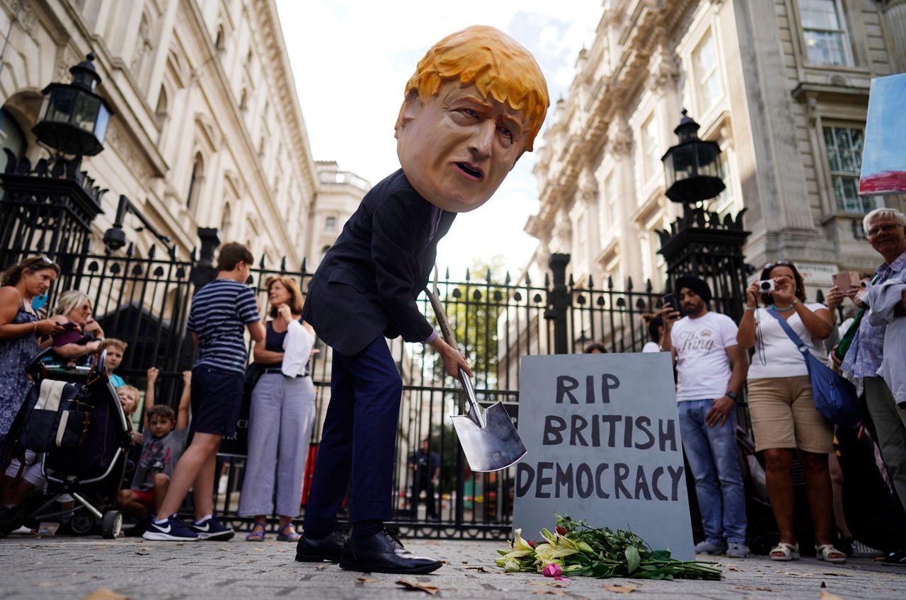 A protester depicting British Prime Minister Boris Johnson demonstrates with a spade outside Downing Street. Source: PA via AAP