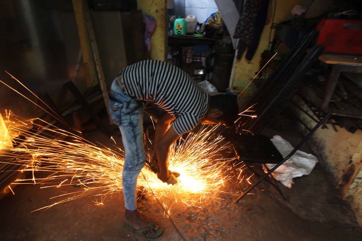 A worker cuts a metal pipe inside a workshop in Mumbai, India on 22 August 2019. (Photo by Himanshu Bhatt/NurPhoto via Getty Images)