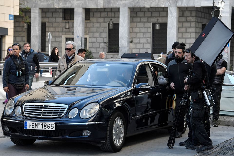 Greek-French film director Costas-Gavras (L) stands near a car during the shooting of the film 'Adults in the room' in central Athens on April 11, 2019. - The political film is based on former Greek Finance minister Yanis Varoufakis' book. (Photo by Louisa GOULIAMAKI / AFP)        (Photo credit should read LOUISA GOULIAMAKI/AFP/Getty Images)