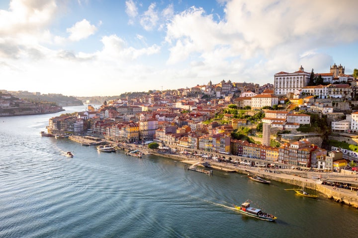 View to Porto over river Douro with reflection of the lights at sunset