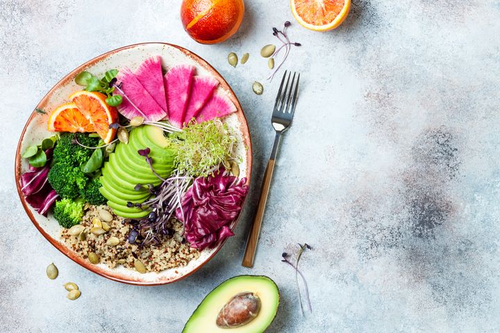 Vegan, detox Buddha bowl with quinoa, micro greens, avocado, blood orange, broccoli, watermelon radish, alfalfa seed sprouts. Top view, flat lay, copy space