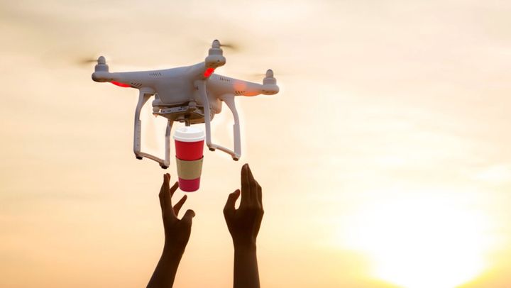 A photoshopped image of a drone delivering Tim Hortons to someone with outstretched hands.