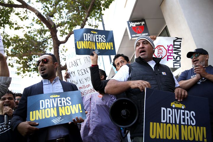 Drivers hold signs during a protest outside Uber headquarters in support of California Assembly Bill 5, Aug. 27, 2019, in San Francisco.