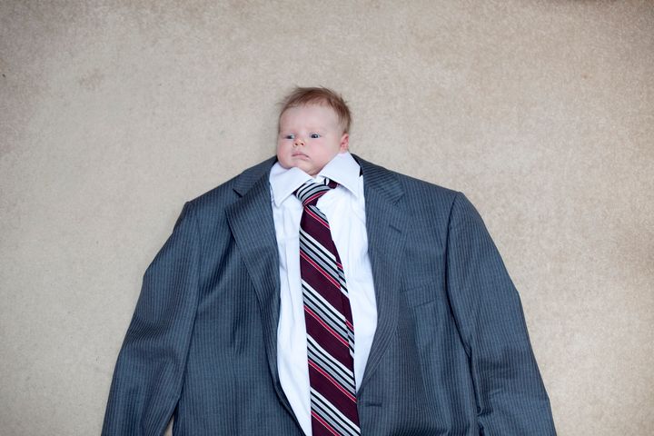 a portrait of a young child dressed in a business suit