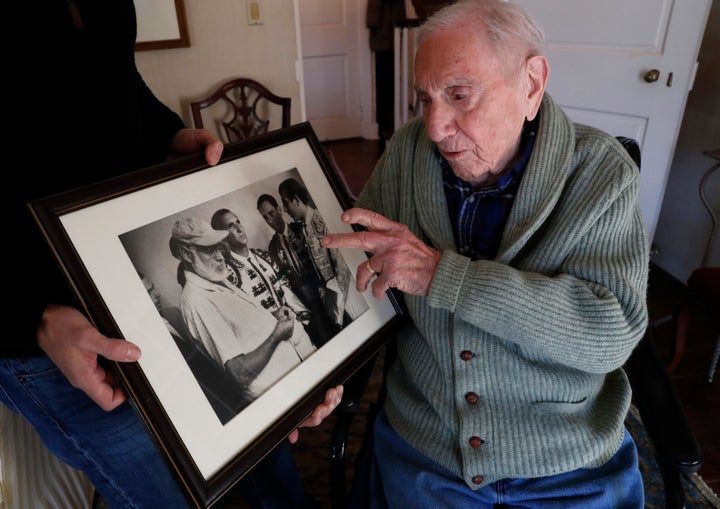 Hemingway's close friend and biographer A.E. Hotchner recounts the story of how he came to perform as a matador in a bullfight at the urging of Hemingway as he looks at a 1959 photograph taken at the event, Tuesday, Jan. 22, 2019, in Westport, Conn. In the photo, Ernest Hemingway is at far left, and Hotchner is second from right. The real matadors are Luis Miguel Dominguin, second from left, and Antonio Ordonez, far right. (AP Photo/Kathy Willens)