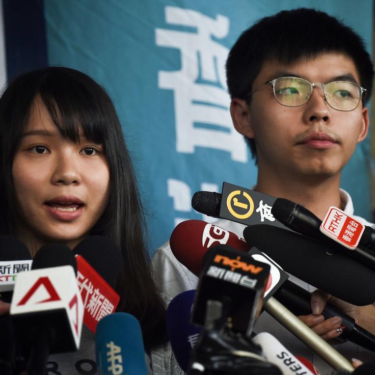 Pro-democracy activists Agnes Chow (L) and Joshua Wong (R) speak to the press after they were released on bail at the Eastern Magistrates Courts in Hong Kong on August 30, 2019. - Prominent democracy activists including a lawmaker were arrested on August 30 in a dragnet across Hong Kong -- a move described by rights groups as a well-worn tactic deployed by China to suffocate dissent ahead of key political events. (Photo by Lillian SUWANRUMPHA / AFP) (Photo credit should read LILLIAN SUWANRUMPHA/AFP/Getty Images)