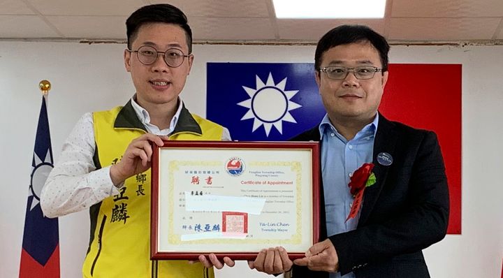 In this photo taken June 20, 2019, Lee Meng-chu, right, accepts a certificate from Archer Chen, left, Chief of Fangliao Township, during a ceremony in southern Taiwan. Taiwan is seeking information from China about Lee, who has gone missing since last week and who had reportedly distributed photos of Chinese troops just outside protest-racked Hong Kong.