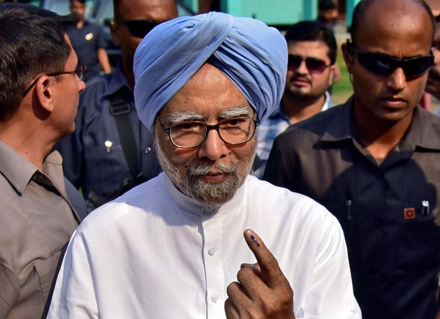 India's former Prime Minister Manmohan Singh shows his ink-marked finger after casting his vote at a...