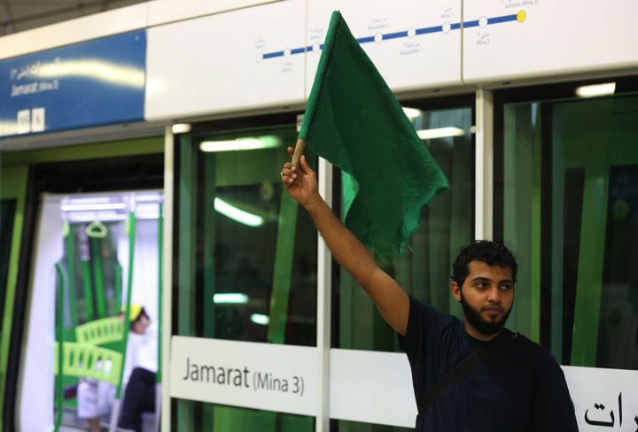 IMAGE USED FOR REPRESENTATIONAL PURPOSES ONLY. (A railway usher raises a green flag to Muslim pilgrims arriving by the Mecca Metro from the mount Arafat area to Mina during the annual Hajj season in the Saudi holy shrine city of Mecca on August 22, 2018. - (Photo credit should read AHMAD AL-RUBAYE/AFP/Getty Images)