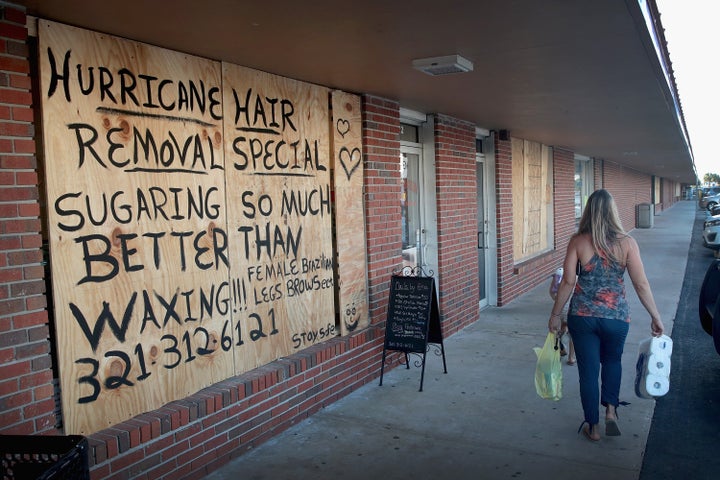 Shoppers grab supplies at a boarded-up strip mall in preparation for Hurricane Dorian on Saturday in Indialantic, Florida.