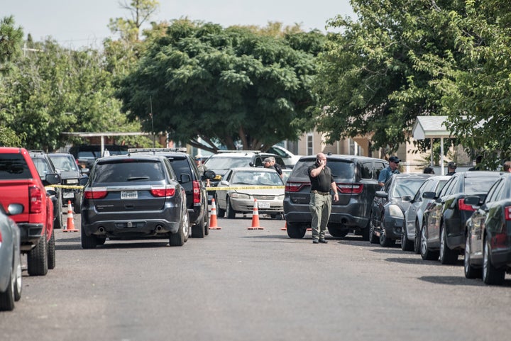 Officers inspect a car in the aftermath of Saturday's deadly shooting in Odessa, Texas.