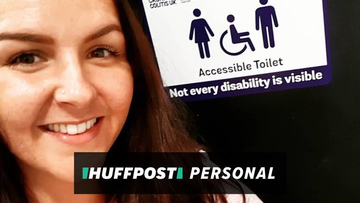 The author, Anna Gaunt, poses with a Crohn's and Colitis accessible toilet sign