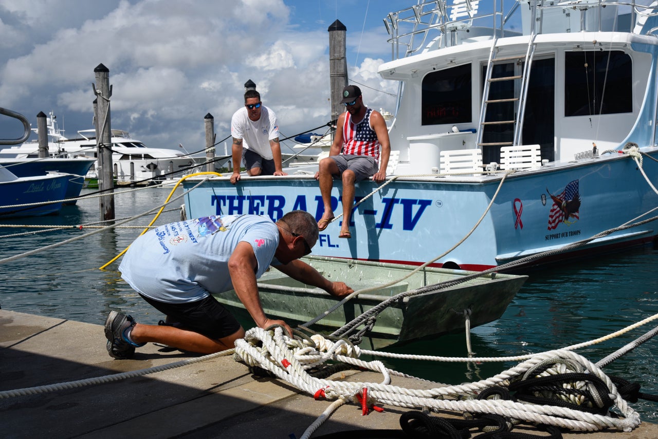 Boat workers Chris Bostwick, Mark and Mike Rodgriguez secure a boat at Haulover Marina in Haulover Beach, Florida, as they prepare for Hurricane Dorian on August 31.