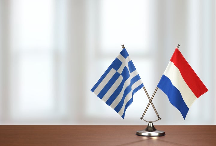 Two crossed national flags on wooden table