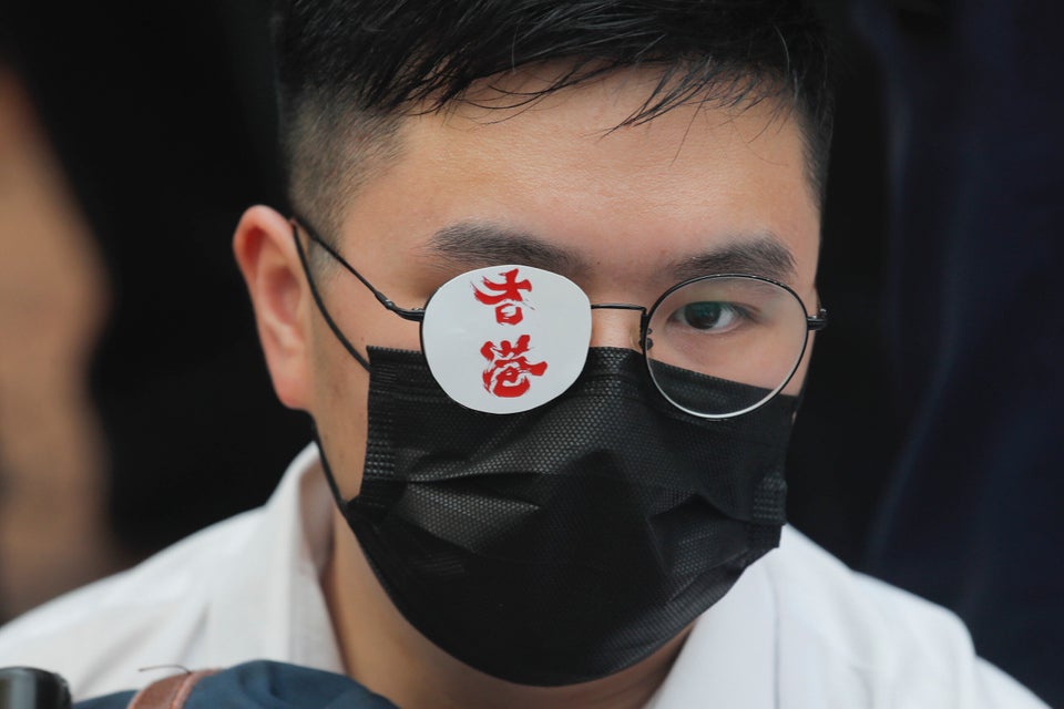 A secondary student covers one eye reading