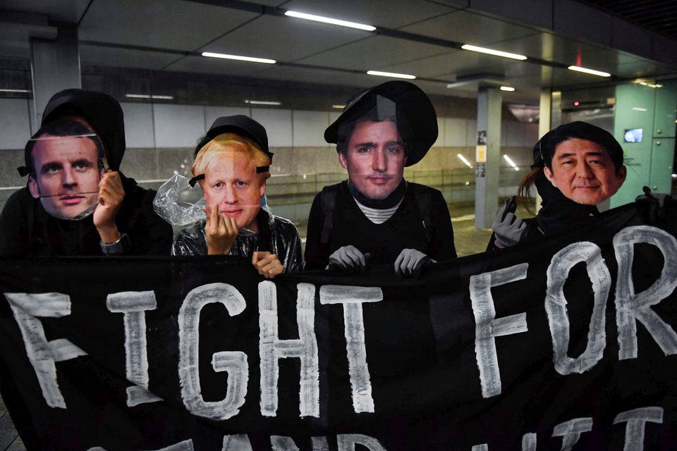 Protesters wearing masks of (L-R) French President Emmanuel Macron, British Prime Minister Boris Johnson,...
