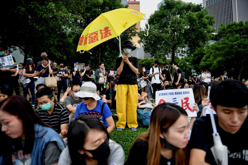 TOPSHOT - A protester (C) holds an umbrella in the latest rally against a controversial extradition bill...