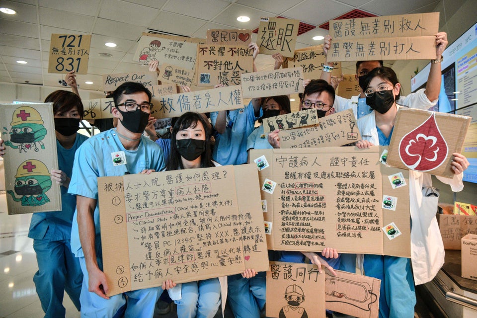 TOPSHOT - Medical staff hold placards after they formed a human chain to express solidarity with anti-extradition...