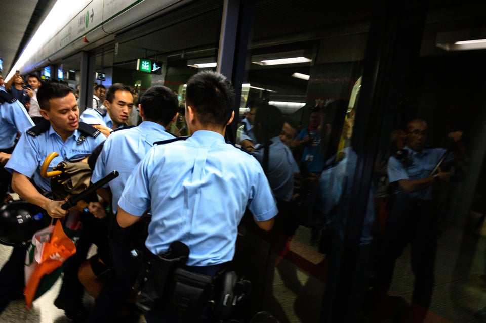 TOPSHOT - A man is arrested at the Lok Fu MTR station during a train disruption protest in Hong Kong...