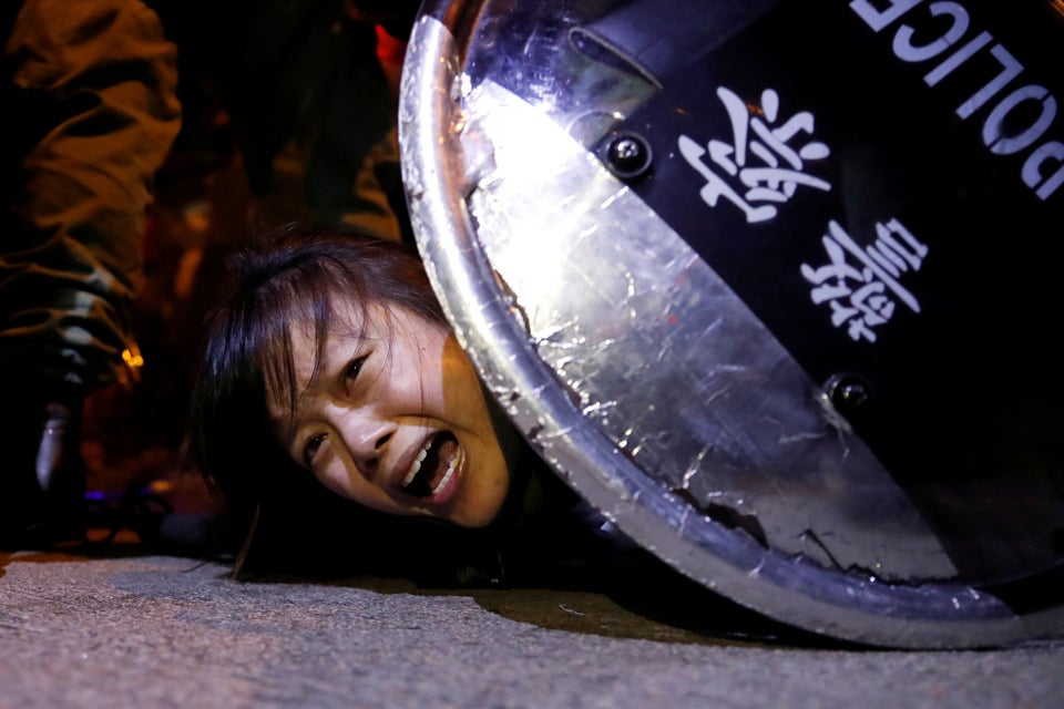 An anti-extradition bill protester is detained by riot police during a protest outside Mong Kok police...