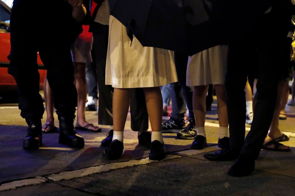 Secondary school students wearing school uniforms attend an anti-extradition bill protest outside Mong...