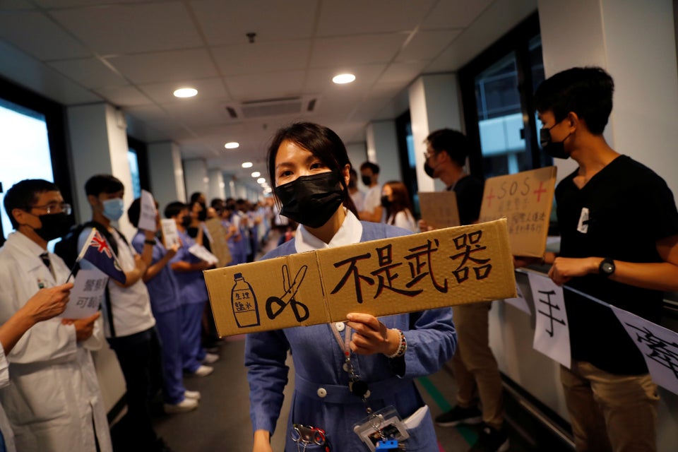 A healthcare staff holds a placard which reads