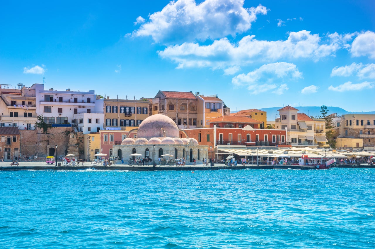 View of the old harbor of Chania with horse carriages and mosque, Crete, Greece.