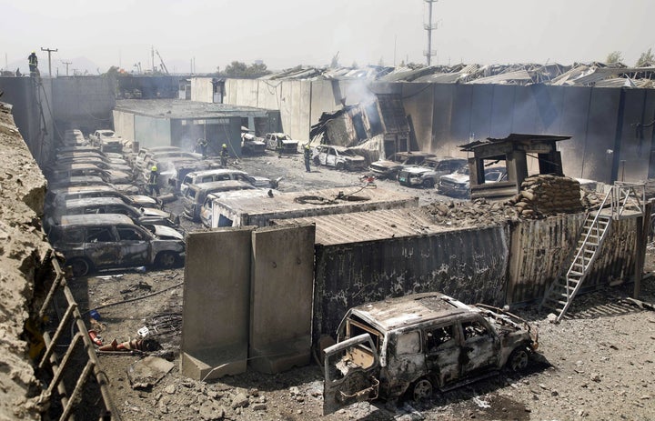 Afghan firefighters work at a parking lot near the site where a tractor packed with explosives exploded the night before at the Green Village in Kabul on September 3, 2019. - A massive blast in a residential area of Kabul killed at least 16 people, officials said September 3, following yet another Taliban attack that came as the insurgents and Washington try to finalise a withdrawal deal. (Photo by STR / AFP) (Photo credit should read STR/AFP/Getty Images)