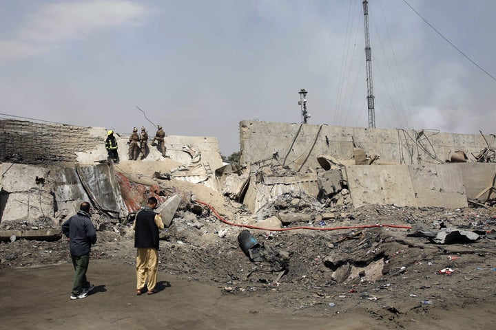 Afghan security forces investigate at the site near the crater from where a tractor packed with explosives exploded the night
