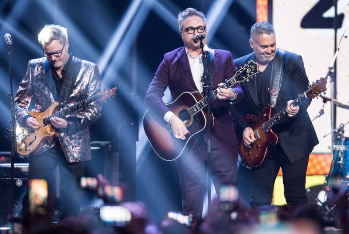 Kevin Hearn, left, and Ed Robertson, right, of the Barenaked Ladies, and former member and co-founder Steven Page, centre, perform during the 2018 Juno Awards in Vancouver, B.C.