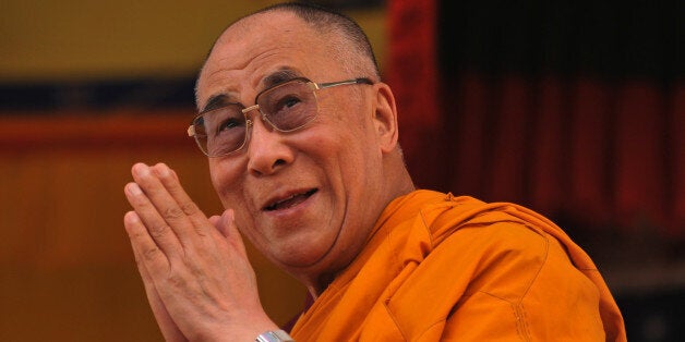 Tibetan spiritual leader the Dalai Lama greets his followers at the Buddhist cultural school in Salugara on the outskirts of Siliguri on March 28, 2013. The Dalai Lama expressed his sorrow for the self immolation protests going on in Tibet while speaking to journalists on his second day of a three day visit in Salugara, in the eastern Indian state of West Bengal after an inauguration ceremony of a 130 foot Lord Buddha statue at Buddha Park. AFP PHOTO/Diptendu DUTTA (Photo credit should